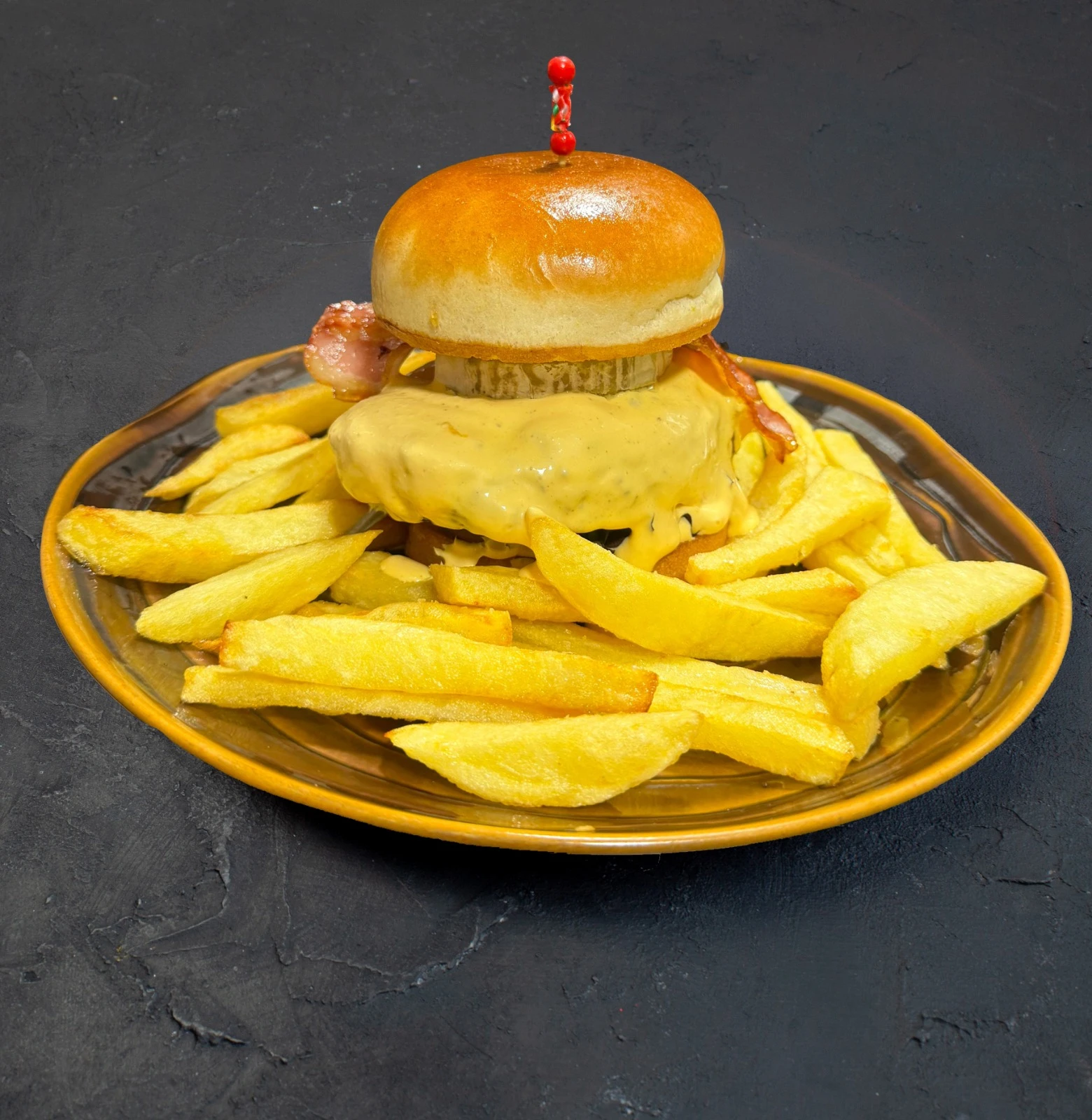 Hamburguesa de la Cervecería Colón sobre cama de patatas